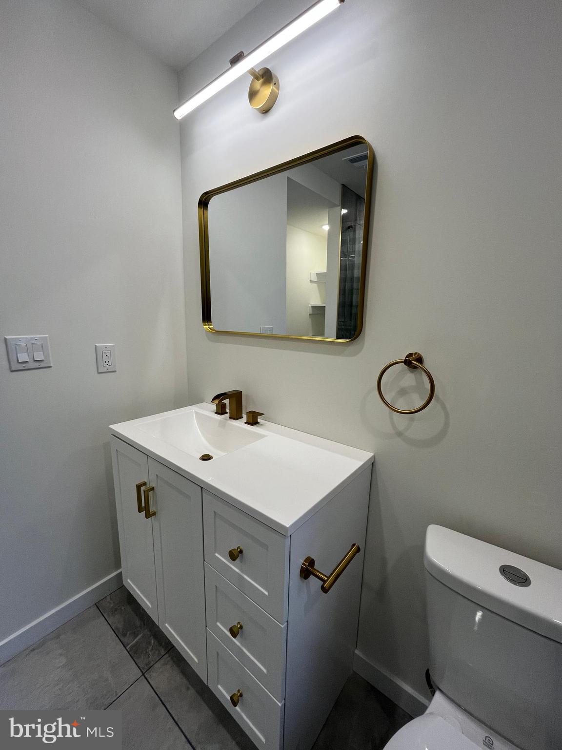 5712 Cedar Avenue Philadelphia, PA 19143 - Photo 31 of 56 a bathroom with a toilet sink and mirror