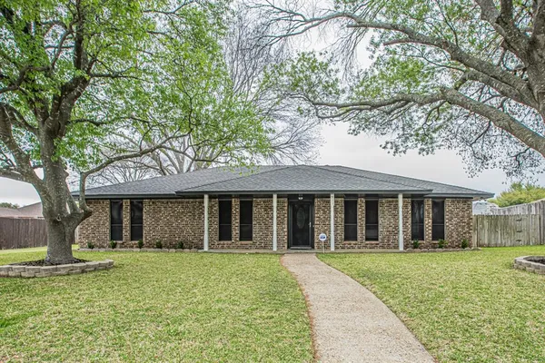 front view of a brick house with a yard