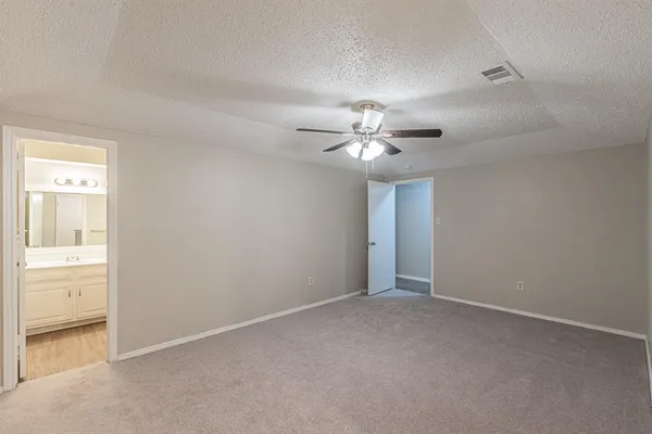 a view of an empty room with a chandelier fan