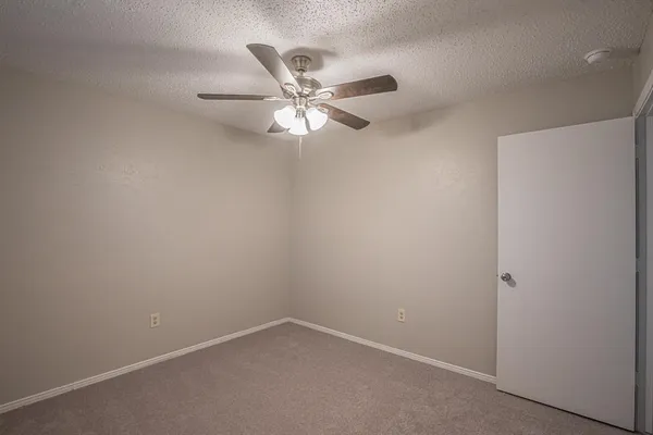 an empty room with a ceiling fan and a window