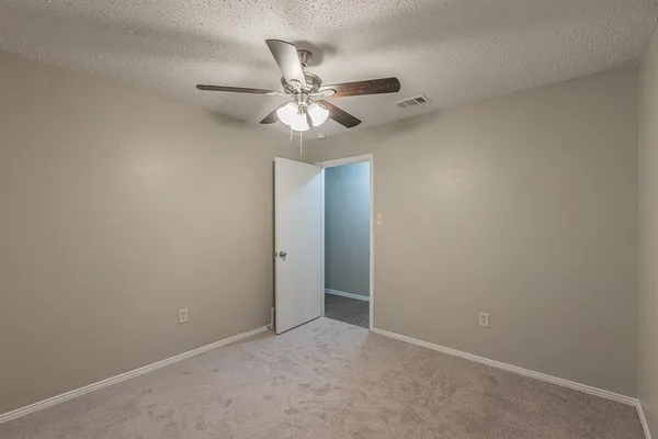 an empty room with a fan and a fan