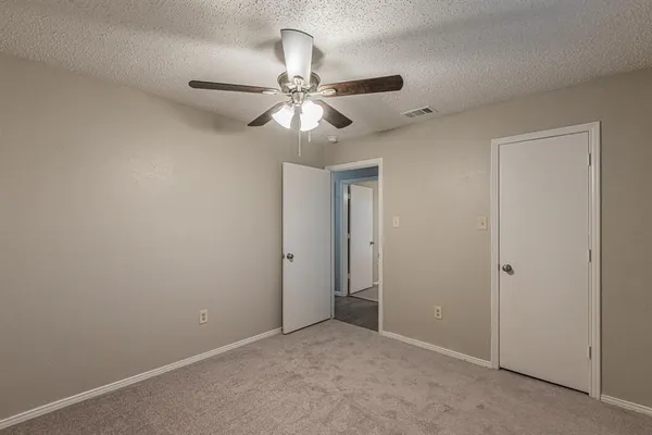 an empty room with a fan and a fan