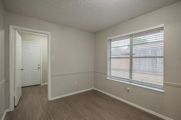 a view of a room with wooden floor and windows