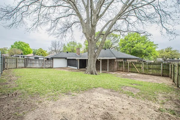 a view of backyard with wooden fence