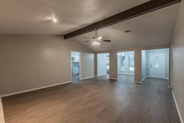 a view of an empty room with wooden floor