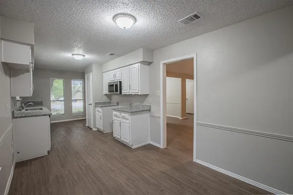 a kitchen with a refrigerator and white cabinets