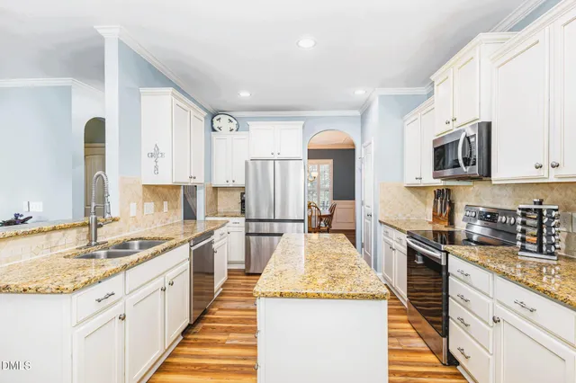 a kitchen with granite countertop white cabinets and refrigerator