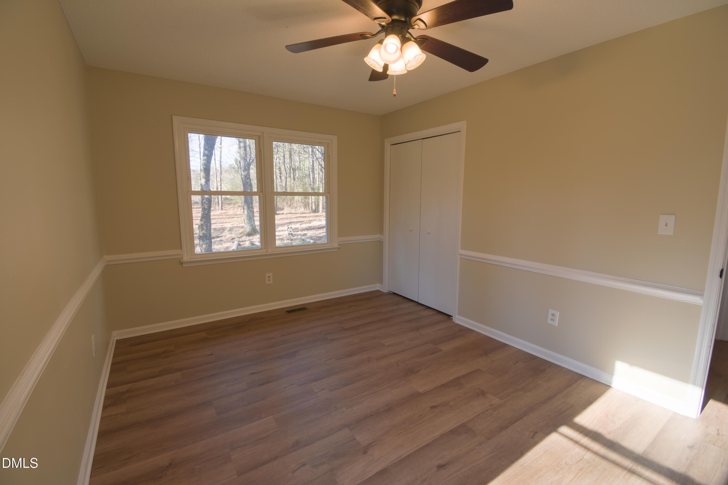 1412 Chamblee Road Zebulon, NC 27597 - Photo 10 of 22 a view of an empty room with wooden floor and a window