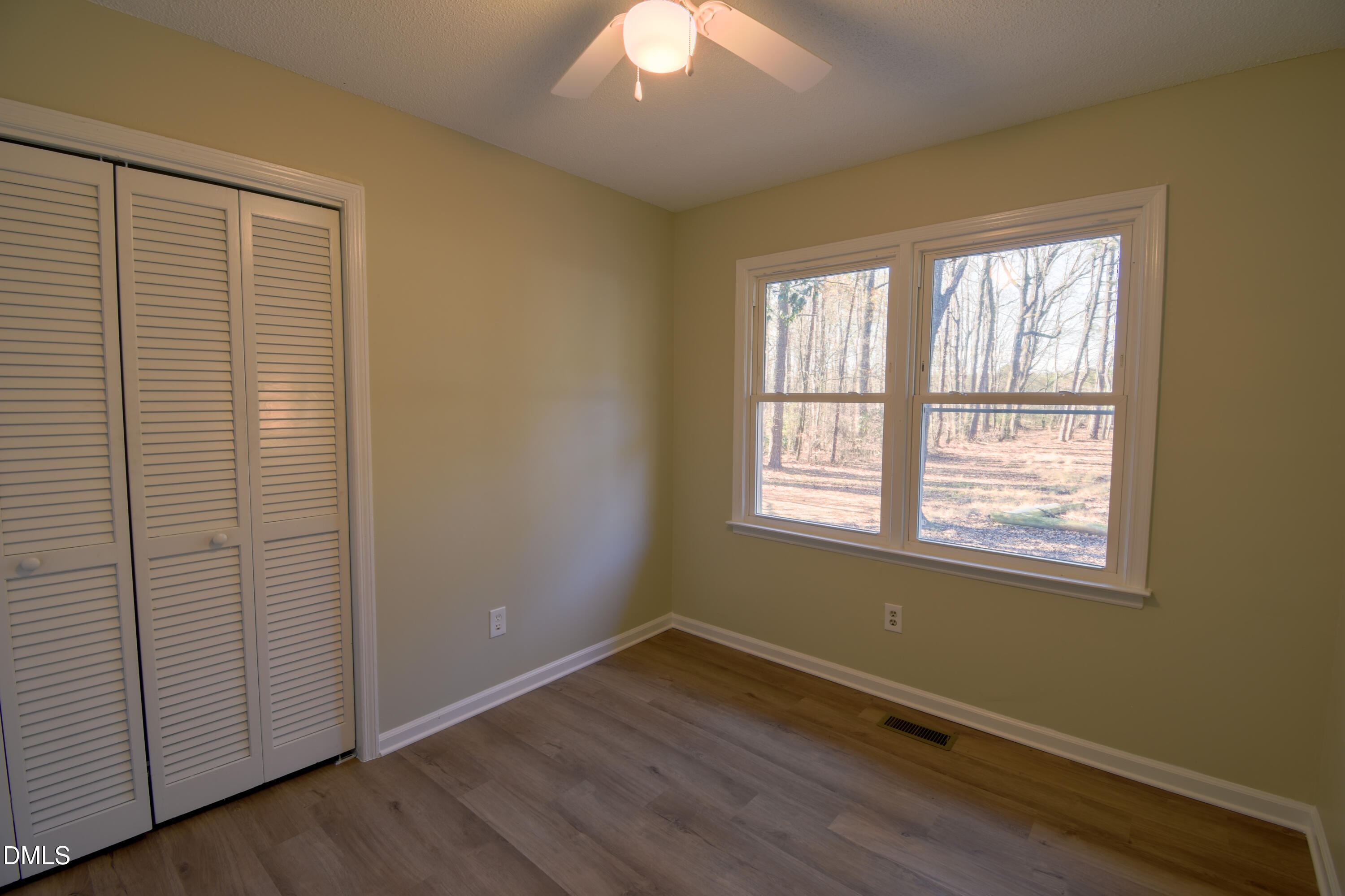 1412 Chamblee Road Zebulon, NC 27597 - Photo 11 of 22 an empty room with wooden floor and windows