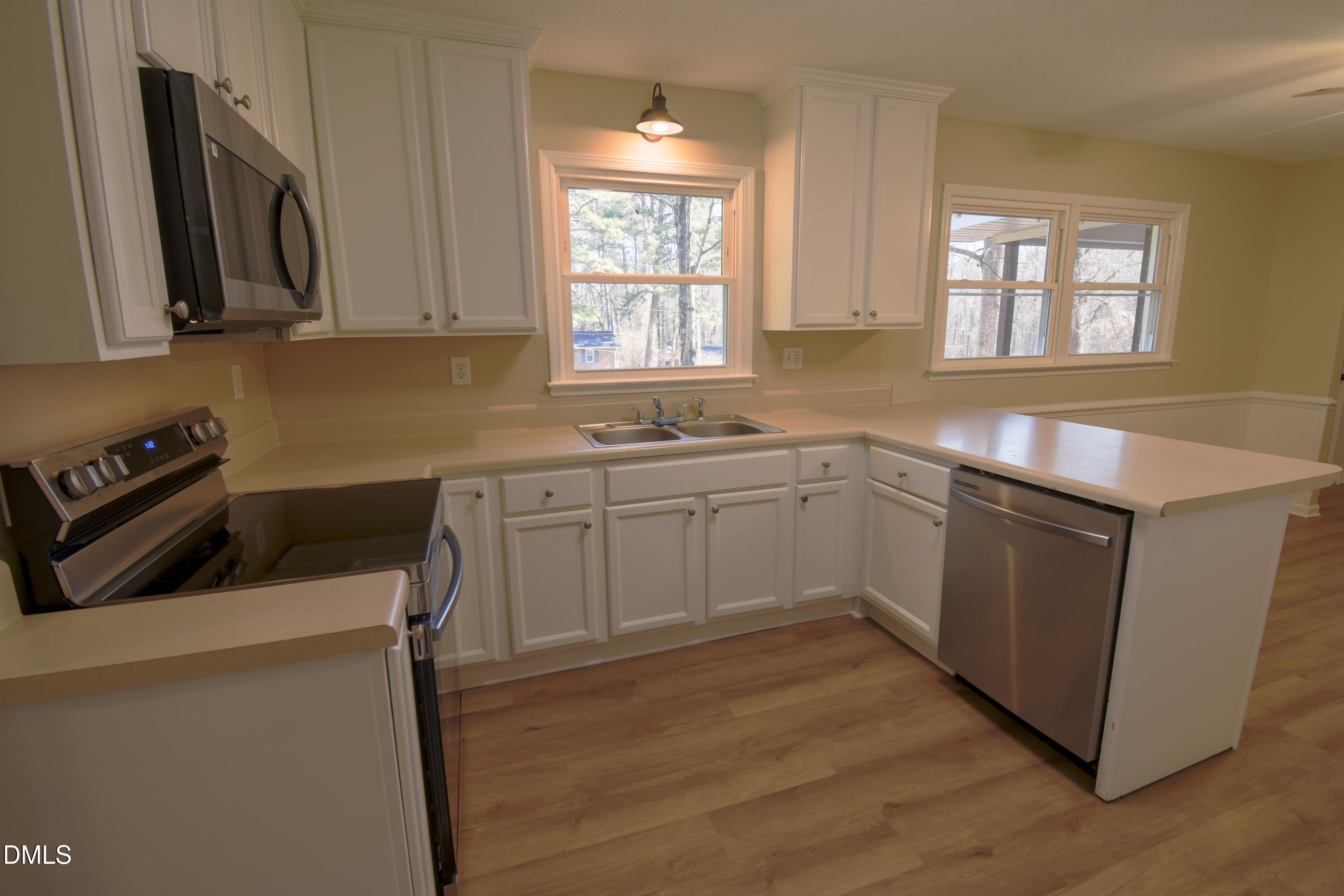 1412 Chamblee Road Zebulon, NC 27597 - Photo 3 of 22 a kitchen with stainless steel appliances a sink a stove a microwave a sink a refrigerator and window