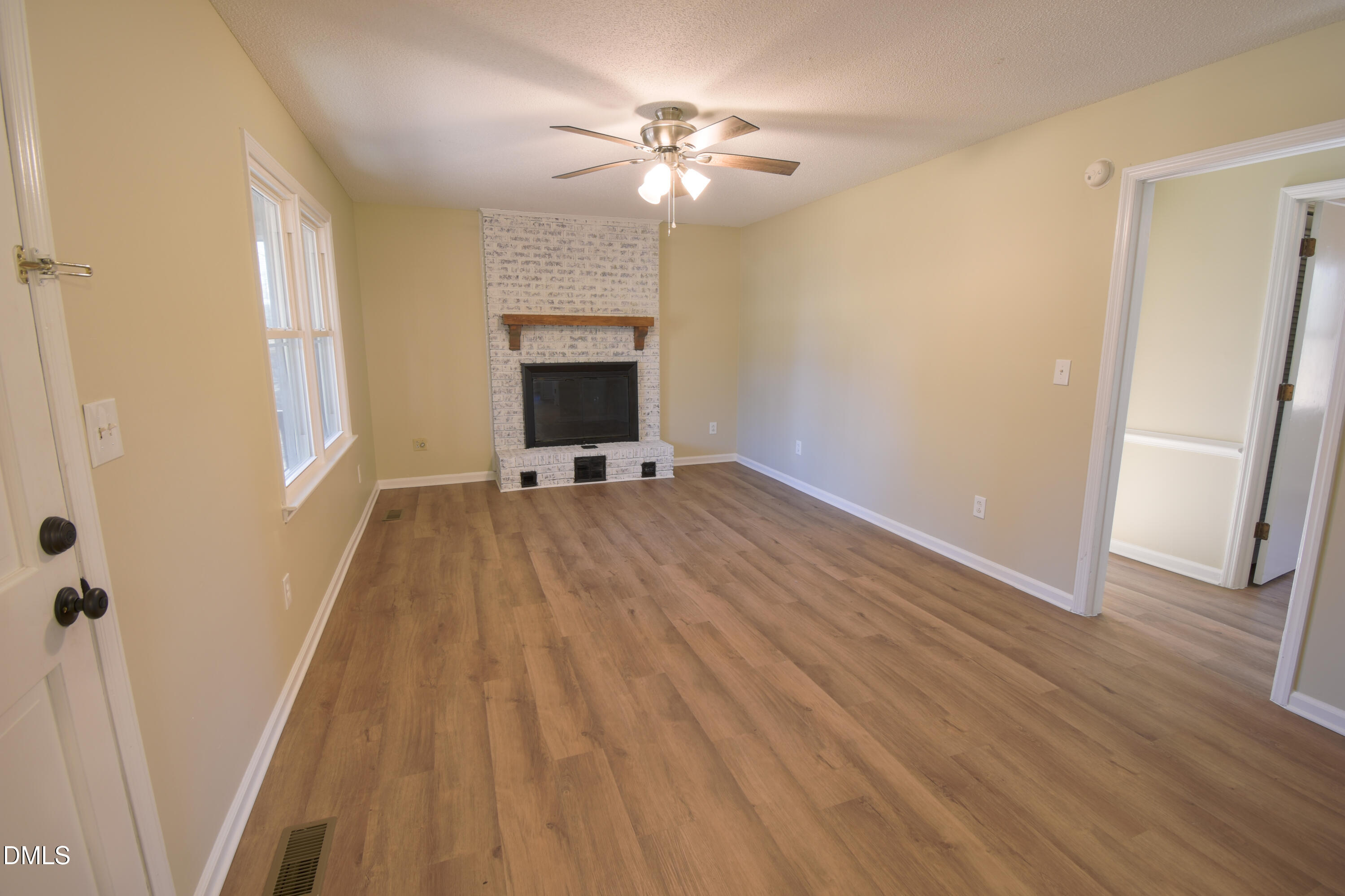 1412 Chamblee Road Zebulon, NC 27597 - Photo 6 of 22 wooden floor in an empty room with a fireplace