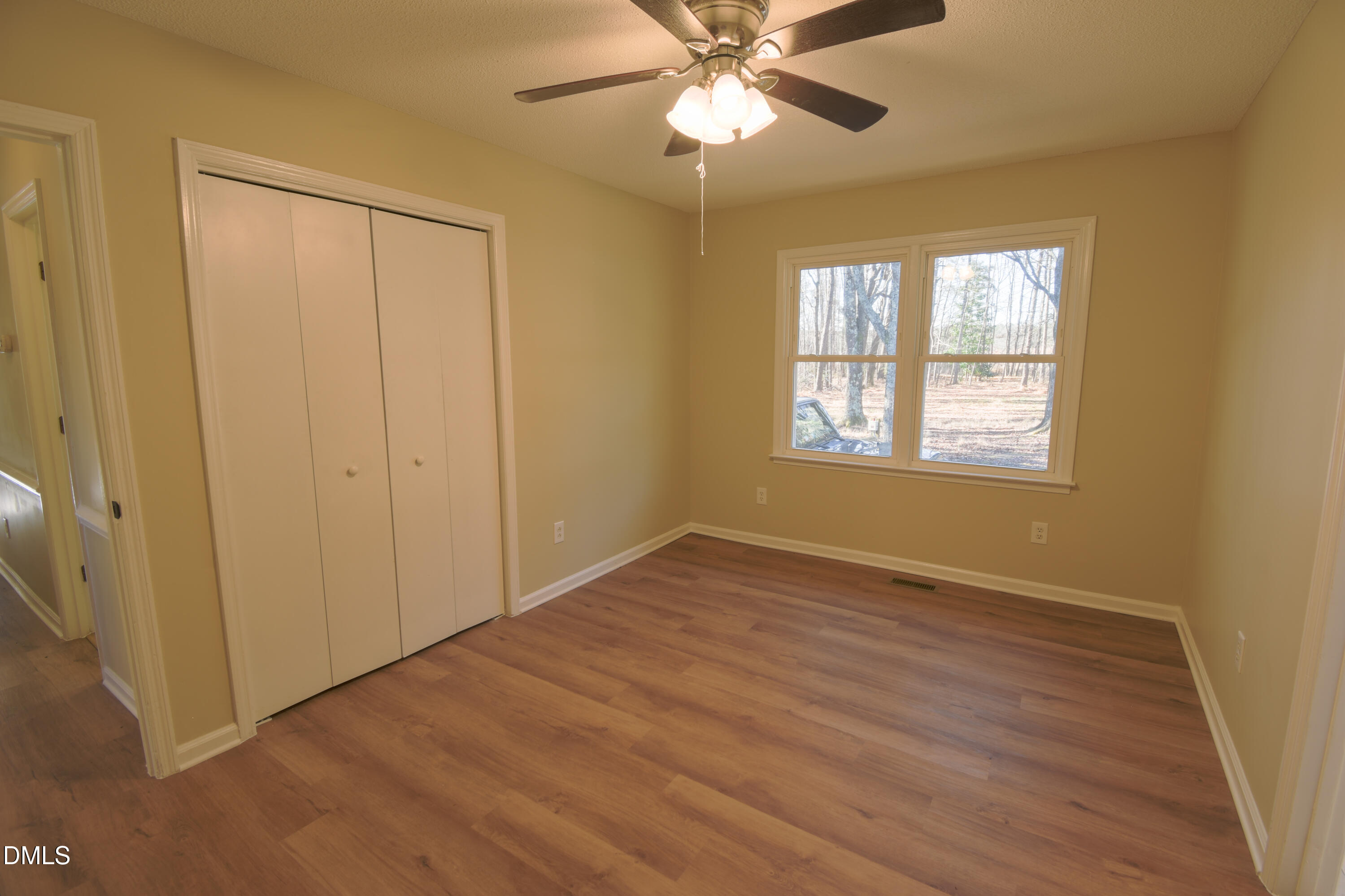 1412 Chamblee Road Zebulon, NC 27597 - Photo 7 of 22 a view of an empty room with wooden floor and a window
