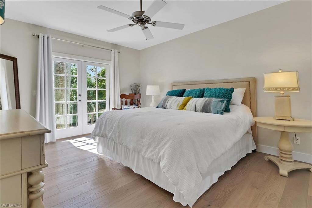 2127 Harlans Run Naples, FL 34105 - Photo 19 of 22 a bedroom with a large bed and a chandelier