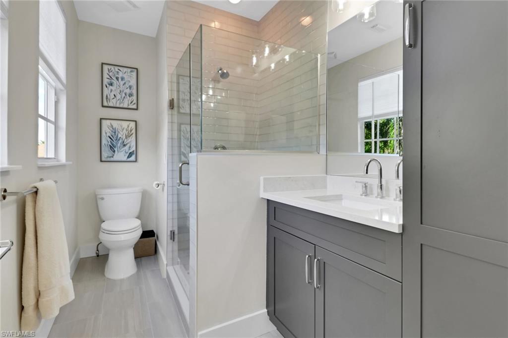 2127 Harlans Run Naples, FL 34105 - Photo 20 of 22 a bathroom with a granite countertop sink a toilet and a shower