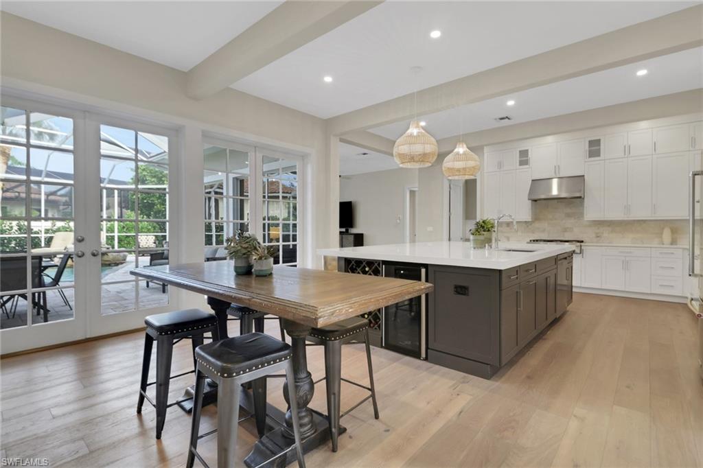 2127 Harlans Run Naples, FL 34105 - Photo 8 of 22 a kitchen with a table chairs and a refrigerator