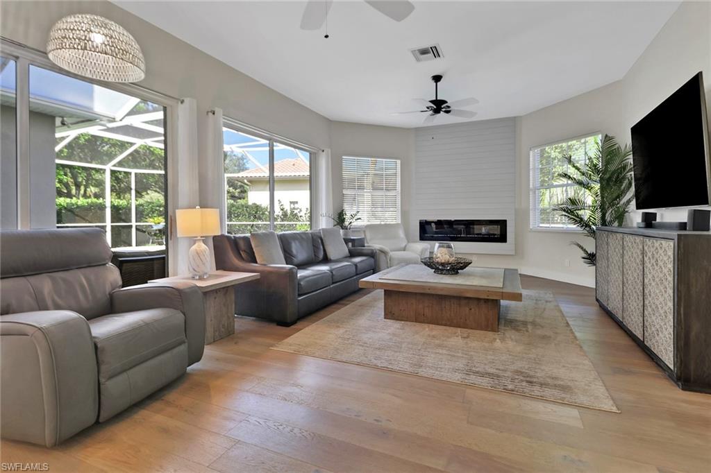 2127 Harlans Run Naples, FL 34105 - Photo 9 of 22 a living room with furniture a flat screen tv and a large window