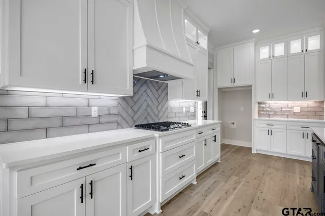 a kitchen with cabinets appliances and wooden floor