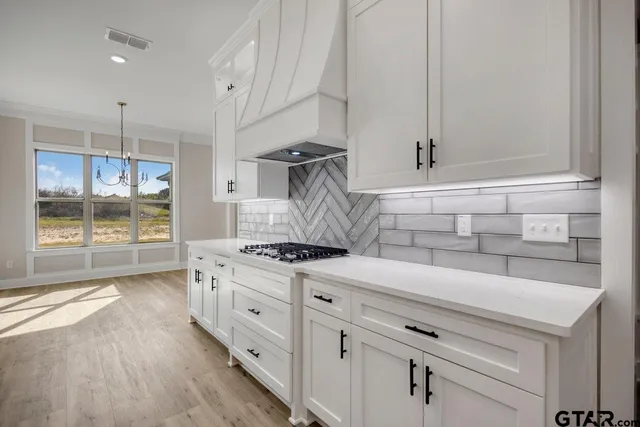 a kitchen with granite countertop a stove and a wooden floors