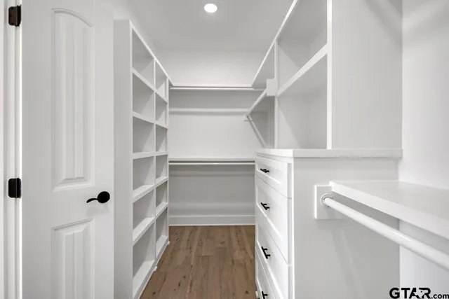 a view of walk in closet with empty racks
