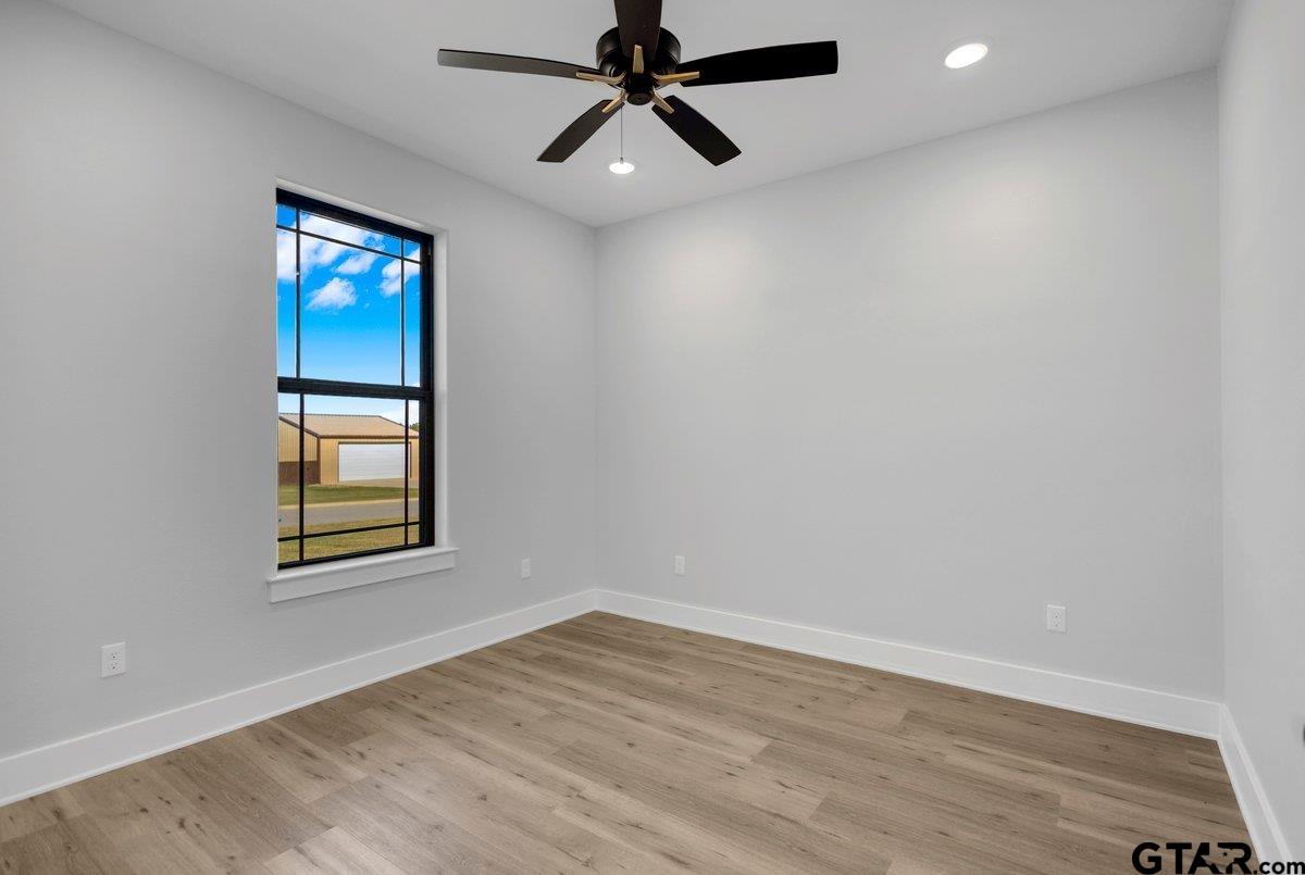 15531 Sugar Rdg Lane Flint, TX 75762 - Photo 42 of 45 an empty room with wooden floor ceiling fan and windows