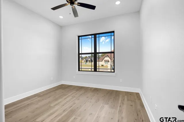 an empty room with a window and wooden floor