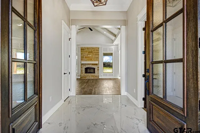 a view of a hallway with wooden floor and a living room