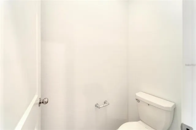 a white toilet sitting next to a white wall