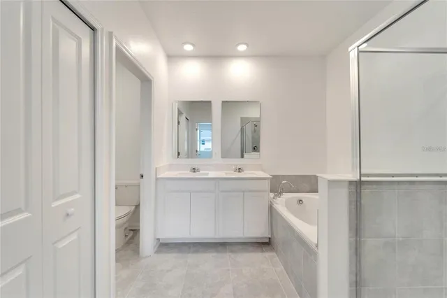 a large white bathroom with a bathtub and a sink