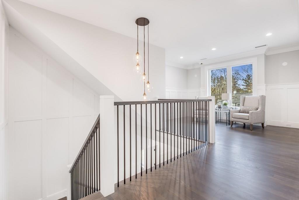 819 Dedham Street Newton, MA 02459 - Photo 22 of 40 a view of a hallway with couches and a dining table with wooden floor