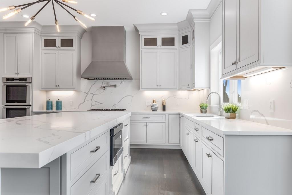 819 Dedham Street Newton, MA 02459 - Photo 5 of 40 a kitchen with kitchen island granite countertop a sink a stove and cabinets