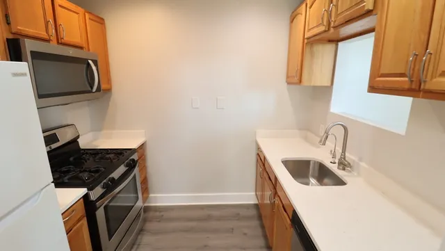 a kitchen with stainless steel appliances granite countertop a sink stove and microwave