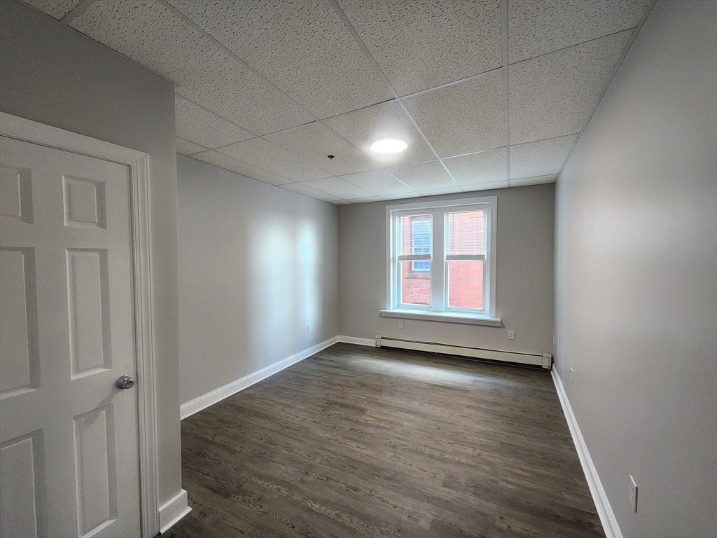 178 High Street, Unit 304 Clinton, MA 01510 - Photo 12 of 26 an empty room with wooden floor and windows