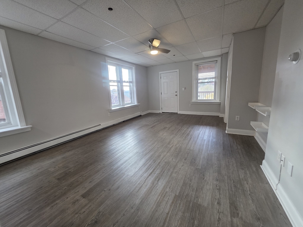 178 High Street, Unit 304 Clinton, MA 01510 - Photo 14 of 26 an empty room with wooden floor and windows