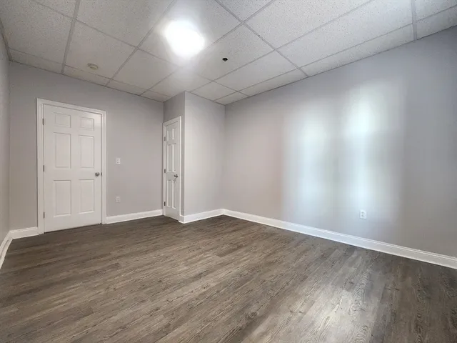 a view of an empty room with wooden floor