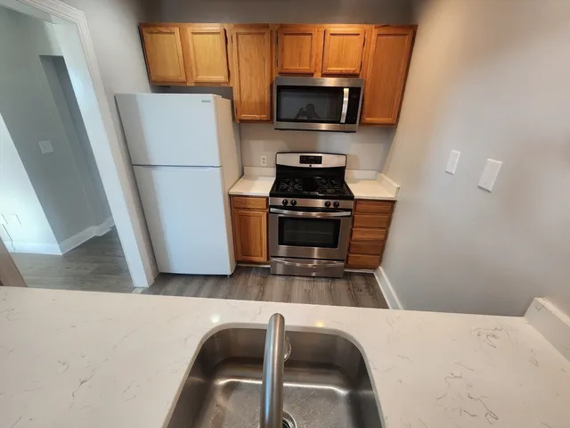 a kitchen with a refrigerator a stove top oven a sink and dishwasher