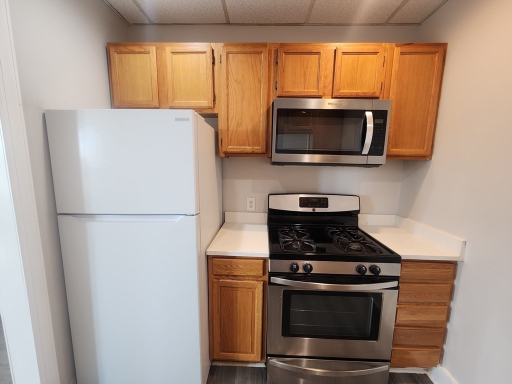 178 High Street, Unit 304 Clinton, MA 01510 - Photo 8 of 26 a kitchen with a stove and a microwave