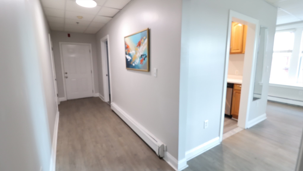 178 High Street, Unit 304 Clinton, MA 01510 - Photo 10 of 26 a view of a hallway with wooden floor and windows