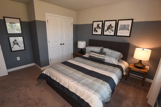 a bedroom with a bed and painting on the wall