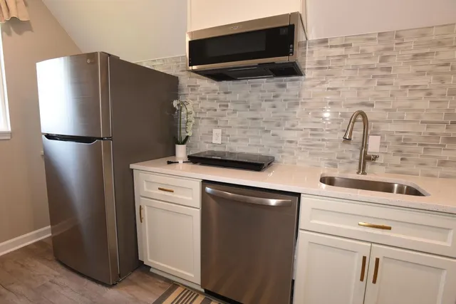 a kitchen with a stainless steel appliances a refrigerator and cabinets