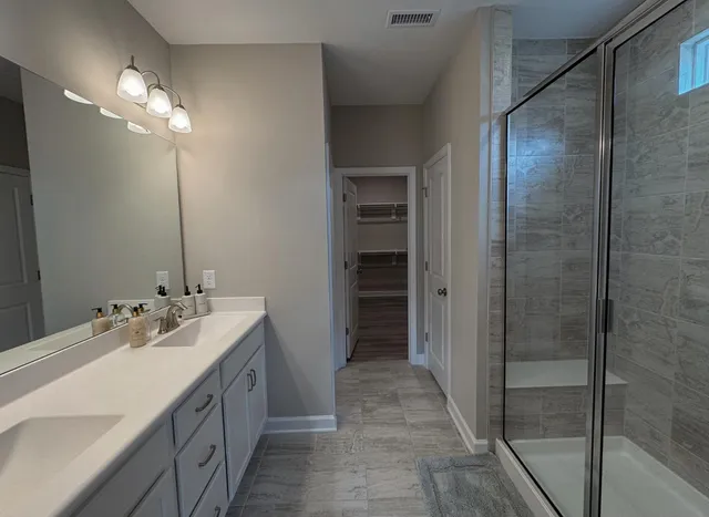 a bathroom with a double vanity sink mirror and shower
