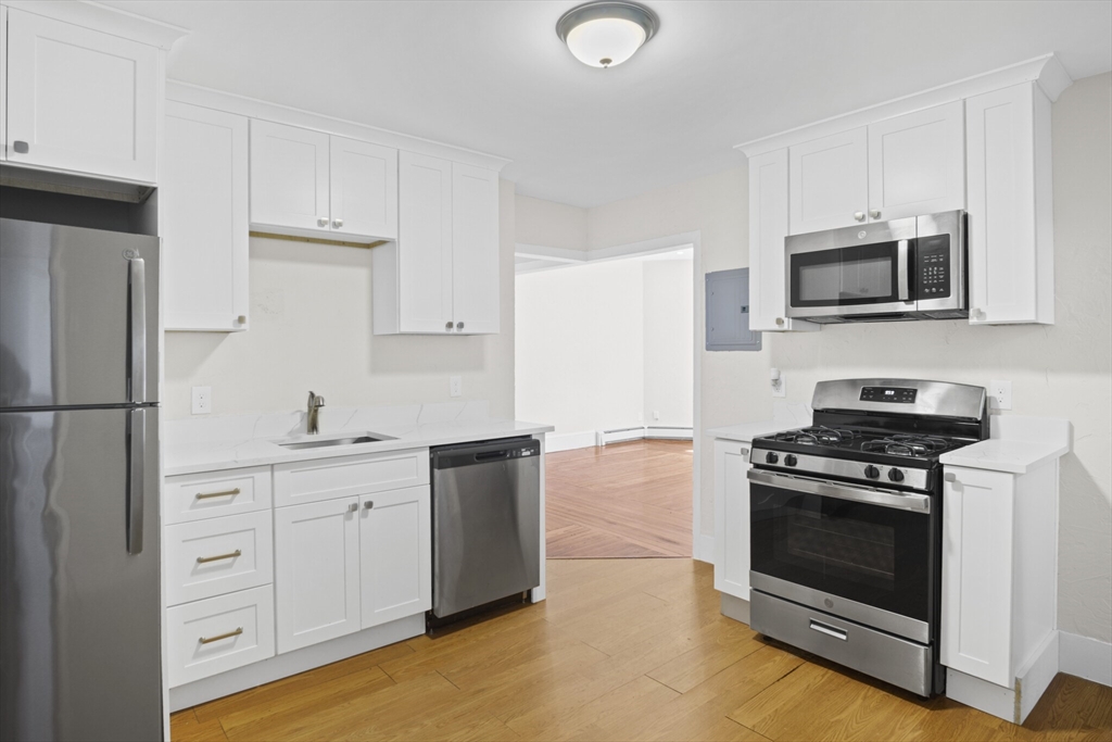 10 Redfield Street, Unit 2 Boston, MA 02122 - Photo 8 of 10 a kitchen with cabinets stainless steel appliances and wooden floor