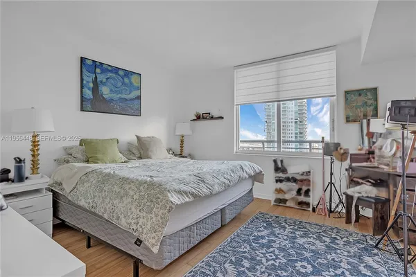 a bedroom with a bed and wooden floor