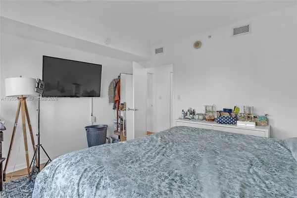 a bedroom with a bed and a flat screen tv