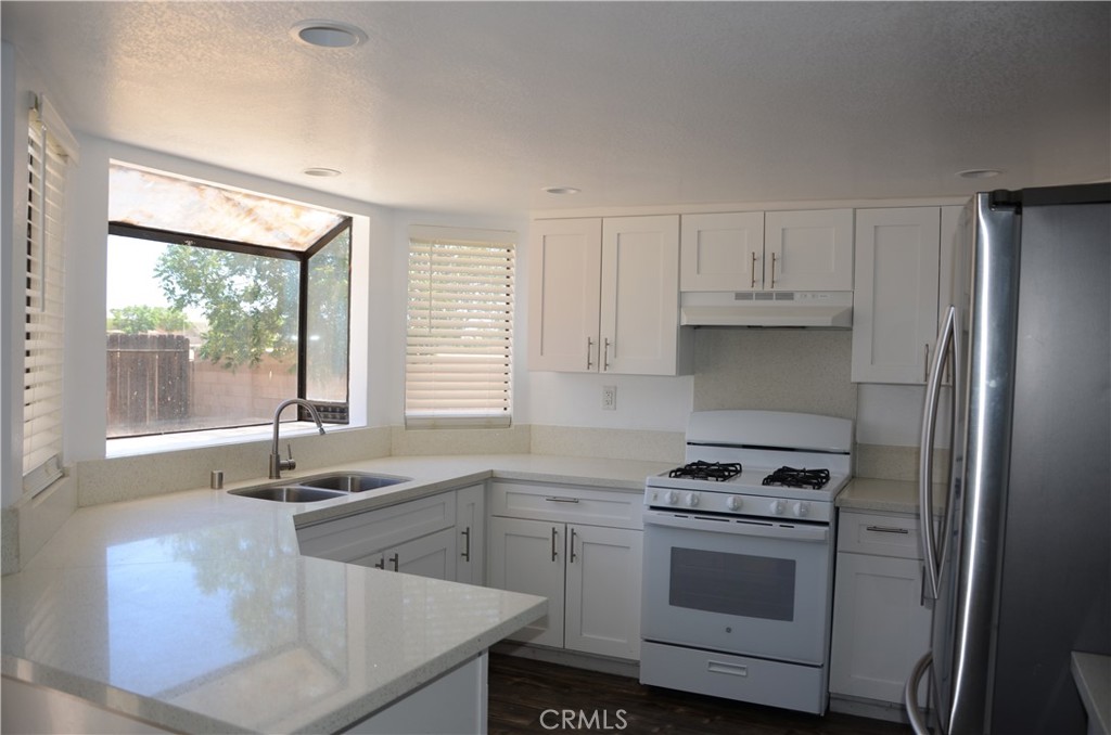 43600 Santa Rosa Circle Lancaster, CA 93535 - Photo 18 of 25 a kitchen with stainless steel appliances granite countertop a sink stove and refrigerator