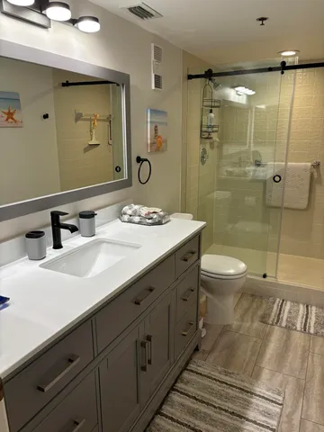 a bathroom with a double vanity sink toilet and shower