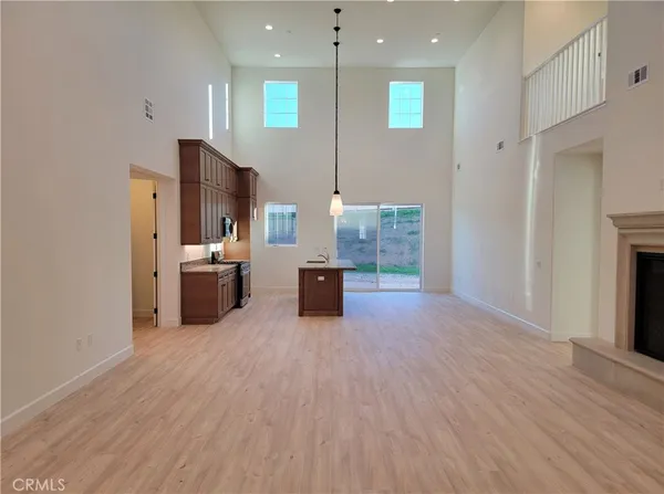 a open kitchen with stainless steel appliances granite countertop a refrigerator a sink dishwasher and a oven with wooden floor
