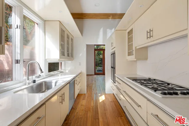 a kitchen with sink a stove and cabinets