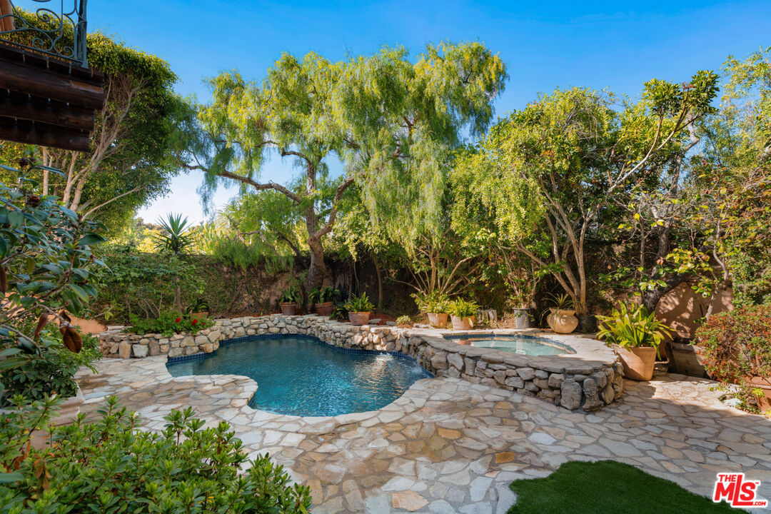 23351 Malibu Colony Road, Unit 108A Malibu, CA 90265 - Photo 13 of 27 a view of a lake with a bench and trees around