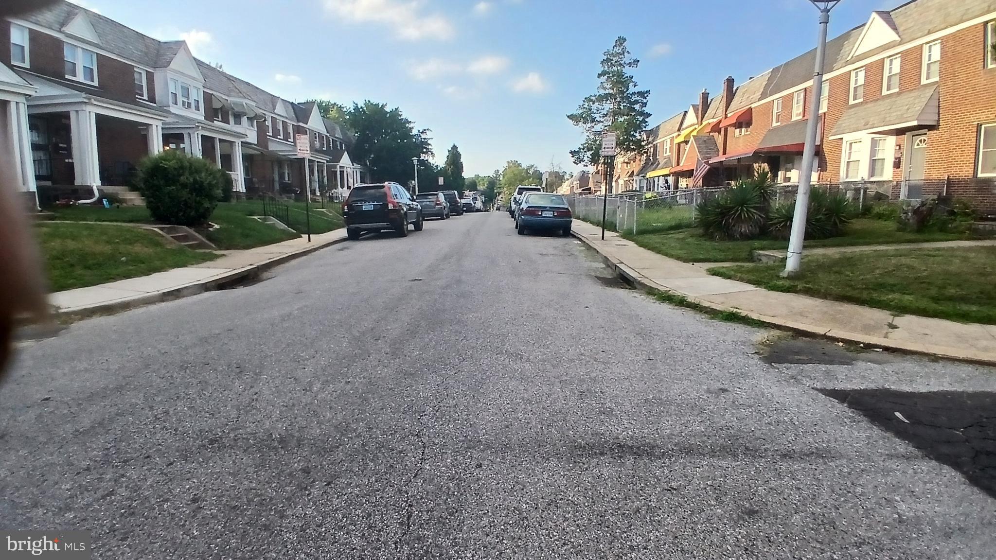 733 Lyndhurst Street Baltimore, MD 21229 - Photo 4 of 8 a view of a street with a apartment building in the background