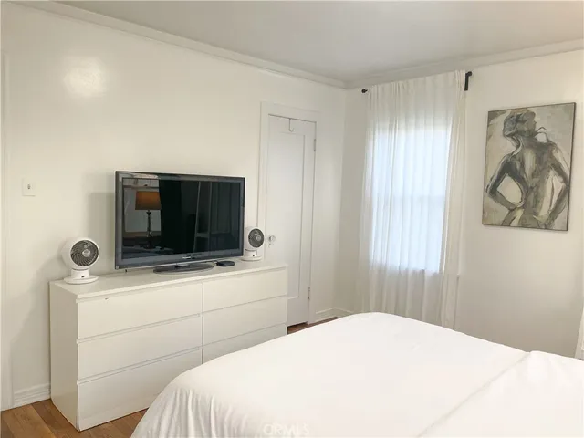 a bedroom with a bed and a flat screen tv